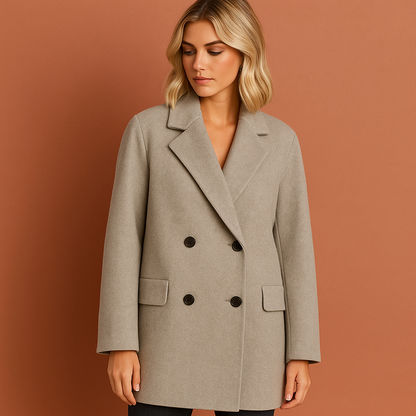 Lange damesjas in grijs met dubbele knopen en omvouwkraag, stijlvol en comfortabel voor herfst en winter.